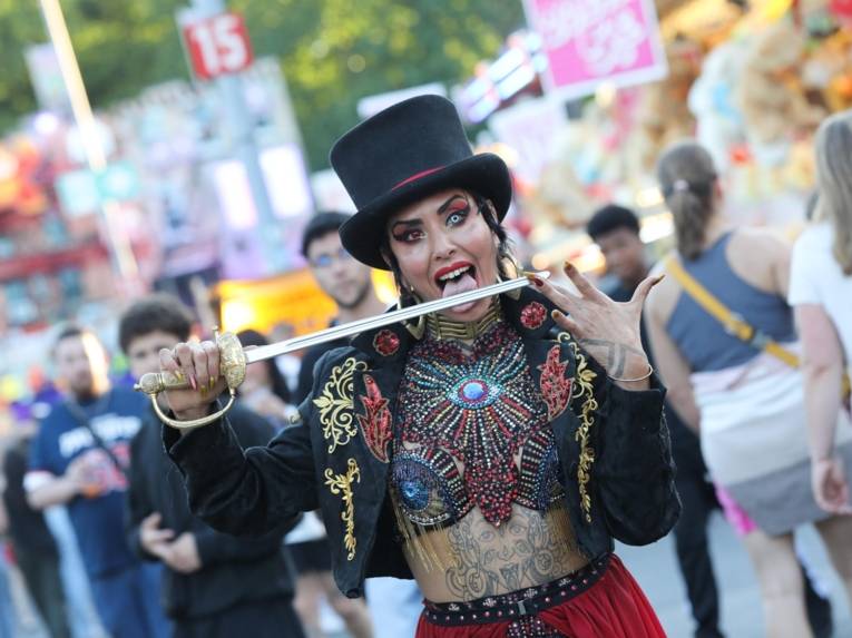 Eine Artistin, die an einem Messer leckt.